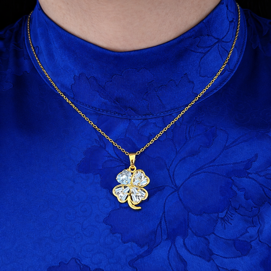 Klaver ketting dames met kristallen hanger gedragen door model op blauwe outfit