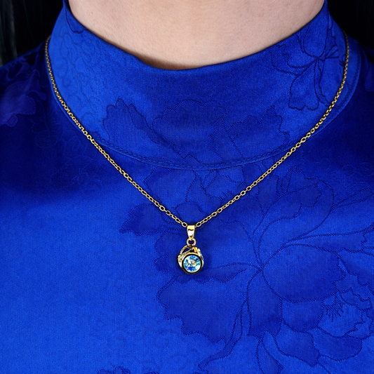 Gouden ketting met blauwe steen hanger gedragen op de hals, elegante damesketting