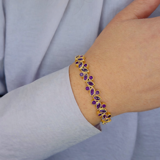 “Gouden armband met paarse stenen gedragen om de pols, luxe en elegant design”