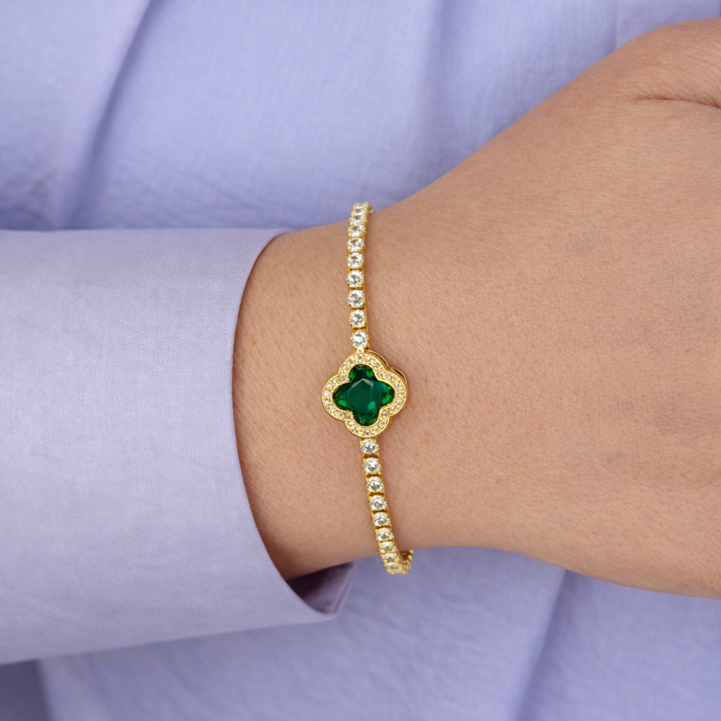 Gouden armband met groene klaversteen en fonkelende zirkonia, gedragen om de pols