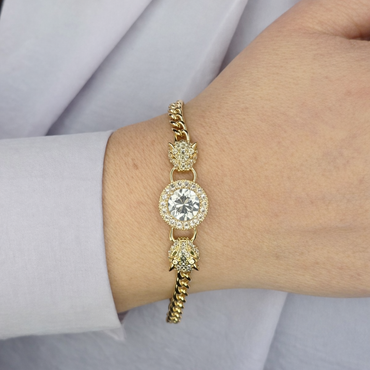 Gouden panter armband met groene ogen en ronde diamantsteen, gedragen om de pols, luxe sieradenfoto voor productpagina.